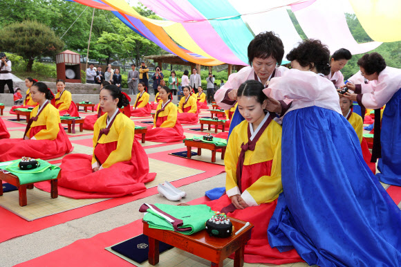 20일 서울 남산골 한옥마을에서 열린 전통 성년례(成年禮)에서 올해로 20세가 된 1993년생대학생 등이 족두리를 착용하기에 앞서 비녀를 꼽고 있다.