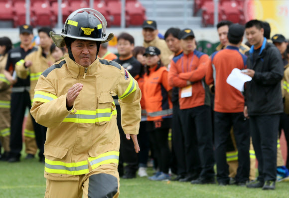 20일 오전 서울 잠실종합운동장 보조경기장에서 열린 ‘2013년 종합소방기술 경연대회’에서 의용소방대원들이 개인장비 장착 릴레이 경기를 하고 있다.