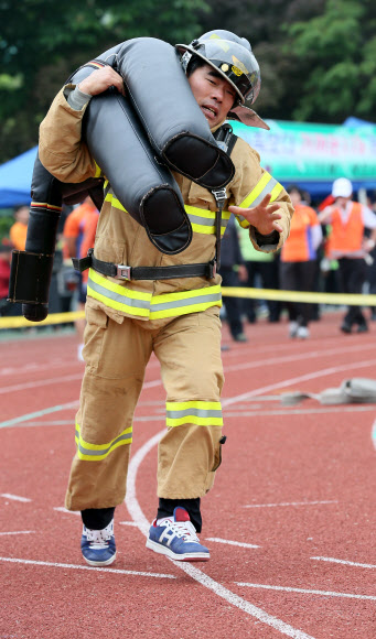 20일 오전 서울 잠실종합운동장 보조경기장에서 열린 ‘2013년 종합소방기술 경연대회’에서 의용소방대원들이 출동단계별 200미터 달리기 경기를 하고 있다.