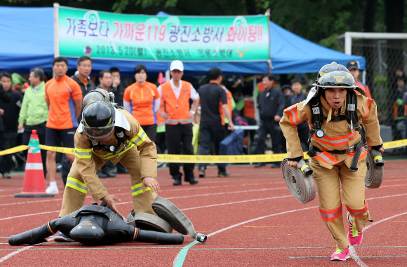20일 오전 서울 잠실종합운동장 보조경기장에서 열린 ‘2013년 종합소방기술 경연대회’에서 의용소방대원들이 출동단계별 200미터 달리기 경기를 하고 있다.