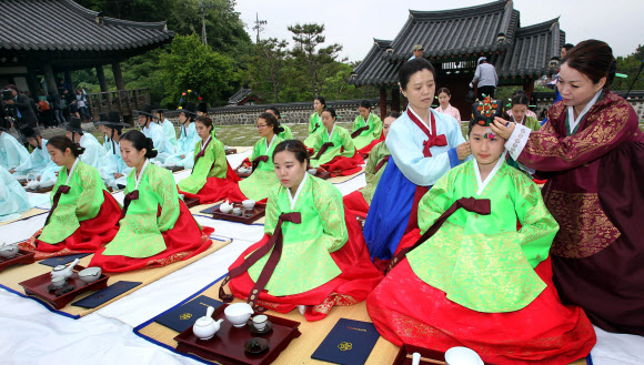 20일 대전시 동구 가양동 우암사적공원 이직당에서 열린 ‘성년의 날’ 행사에서 행사 관계자들이  성년을 맞은 한 여대생의 머리에 비녀를 꽂아주고 있다. 이날 행사에는 지역 대학생과 유학생, 가족 등 400여명이 참석했다.