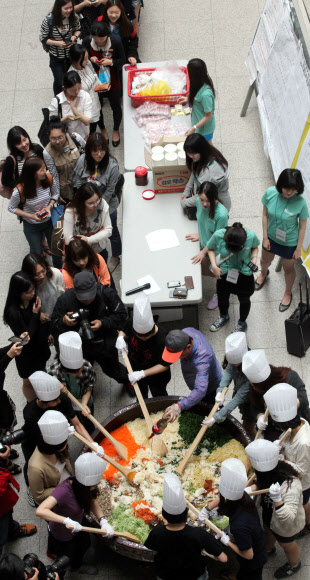 22일 이화여대에서 창립 127주년 대동제를 기념해 ‘이화인 한솥밥 먹기’ 행사가 진행되고 있다. 300인분의 대형 비빔밥을 만들어 재학생들에게 나눠주는 행사다. 올해 대동제의 테마는 ‘모자이크’다. 연합뉴스