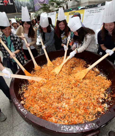 22일 이화여대에서 창립 127주년 대동제를 기념해 ‘이화인 한솥밥 먹기’ 행사가 진행되고 있다. 300인분의 대형 비빔밥을 만들어 재학생들에게 나눠주는 행사다. 올해 대동제의 테마는 ‘모자이크’다. 연합뉴스