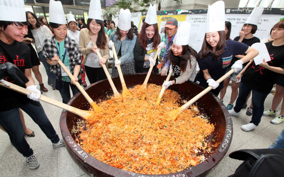 22일 이화여대에서 창립 127주년 대동제를 기념해 ‘이화인 한솥밥 먹기’ 행사가 진행되고 있다. 300인분의 대형 비빔밥을 만들어 재학생들에게 나눠주는 행사다. 올해 대동제의 테마는 ‘모자이크’다. 연합뉴스