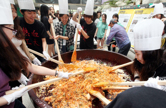 22일 이화여대에서 창립 127주년 대동제를 기념해 ‘이화인 한솥밥 먹기’ 행사가 진행되고 있다. 300인분의 대형 비빔밥을 만들어 재학생들에게 나눠주는 행사다. 올해 대동제의 테마는 ‘모자이크’다. 연합뉴스