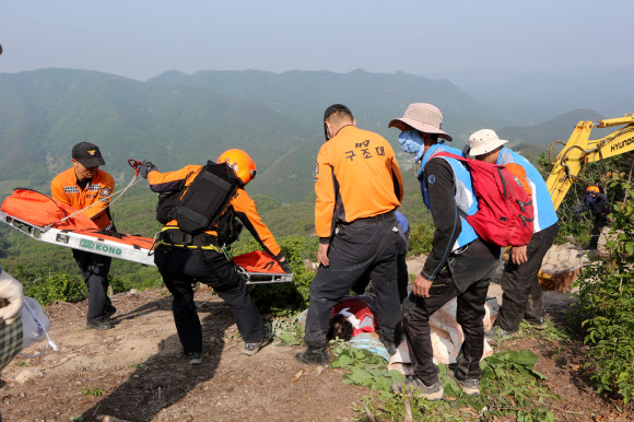 한전이 밀양 송전탑 공사를 재개한지 사흘째인 22일 경남 밀양시 단장면 바드리 백마산(772m) 정상 88번 송전탑 공사현장에서 60대 주민 2명이 경찰과의 충돌 과정에서 다쳐 119 구조대가 환자를 돌보고 있다. 연합뉴스