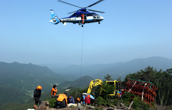 한전이 밀양 송전탑 공사를 재개한지 사흘째인 22일 경남 밀양시 단장면 바드리 백마산(772m) 정상 88번 송전탑 공사현장에서 60대 주민 2명이 경찰과의 충돌 과정에서 다쳐 헬기로 긴급 후송되고 있다. 연합뉴스 