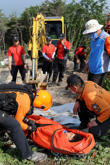 한전이 밀양 송전탑 공사를 재개한지 사흘째인 22일 경남 밀양시 단장면 바드리 백마산(772m) 정상 88번 송전탑 공사현장에서 60대 주민 2명이 경찰과의 충돌 과정에서 다쳐 119 구조대원이 구호조치를 하고 있다. 연합뉴스