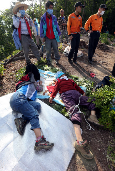 한전이 밀양 송전탑 공사를 재개한지 사흘째인 22일 경남 밀양시 단장면 바드리 백마산(772m) 정상 88번 송전탑 공사현장에서 60대 주민 2명이 경찰과의 충돌 과정에서 다쳐 소방헬기의 구조를 기다리고 있다. 연합뉴스