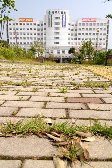 경남도의 폐업 유보 시한 마지막 날인 22일 진주의료원 입구 인도에 잡초가 무성하게 자라 을씨년스런 분위기를 연출하고 있다. 연합뉴스