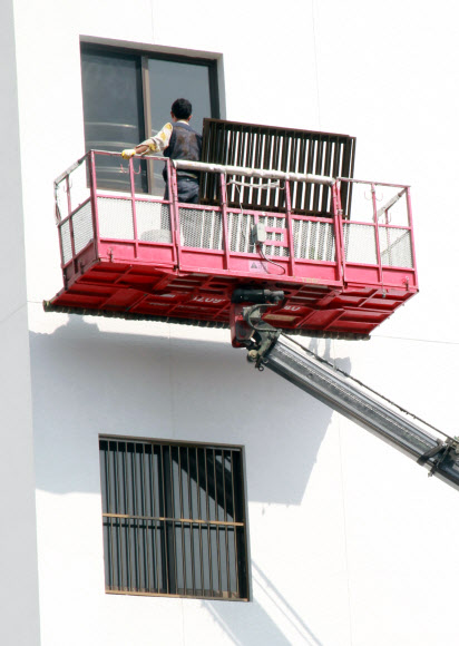 보건의료노조가 홍준표 도지사 면담을 요구하며 21일 오후부터 경남도청 정문 현관 앞에서 연좌농성에 들어가는 등 긴장이 고조되는 가운데 경남도가 진주의료원 폐업 유보시한으로 밝힌 22일 작업인부가 경남도청 본관 측면 유리창에 알루미늄 창틀을 설치하고 있다.  연합뉴스