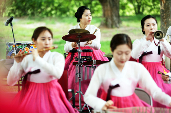 22일 오전 서울 국립민속박물관에서 열린 ‘정자나무 그늘 수요민속음악회’에서 국악 오케스트라 단원들이 연주하고 있다.  연합뉴스