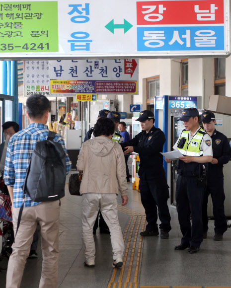 전주지검 남원지청에서 조사 도중 달아난 특수절도범 이대우(46)가 숨어있을 것으로 추정되는 전북 정읍시내의 시외버스터미널에서 경찰관들이 검문검색을 하며 피의자의 인적사항이 담긴 전단지를 나눠주고 있다.  연합뉴스