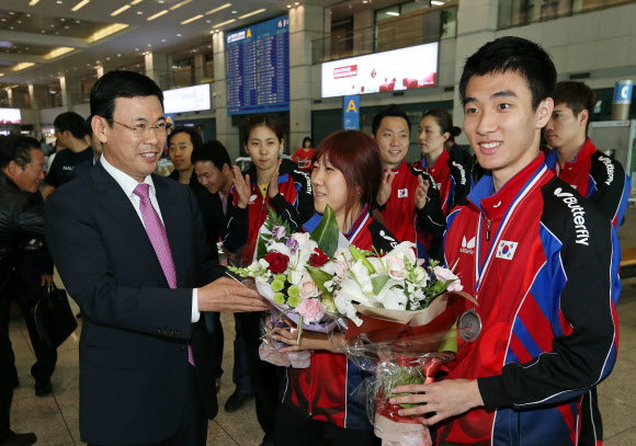 탁구세계선수권대회 혼합복식에서 은메달을 획득한 이상수과 박영숙이 22일 인천국제공항을 통해 귀국, 박주봉 대한탁구협회 부회장으로 부터 꽃다발을 받고 있다. 연합뉴스