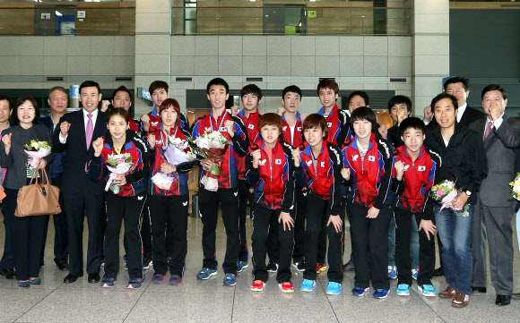 탁구세계선수권대회 혼합복식에서 은메달을 획득한 이상수과 박영숙이 22일 인천국제공항을 통해 귀국, 박주봉 대한탁구협회 부회장 등 선수, 임원들과 함께 기념촬영을 하며 구호를 외치고 있다.   연합뉴스