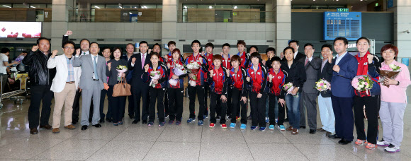 탁구세계선수권대회 혼합복식에서 은메달을 획득한 이상수과 박영숙이 22일 인천국제공항을 통해 귀국, 박주봉 대한탁구협회 부회장 등 선수, 임원들과 함께 기념촬영을 하며 구호를 외치고 있다.     연합뉴스