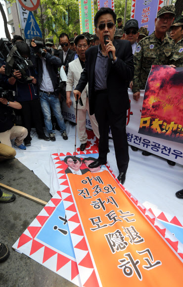주한일본대사관 앞에 모인 대한민국고엽제전우회 등 보수단체 회원들이 아베 일본 총리와 하시모토 오사카 시장의 얼굴이 인쇄된 현수막을 태우려 하고 있다. 연합뉴스