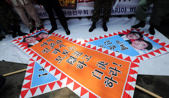 주한일본대사관 앞에 모인 대한민국고엽제전우회 등 보수단체 회원들이 아베 일본 총리와 하시모토 오사카 시장의 얼굴이 인쇄된 현수막을 태우려 하고 있다. 연합뉴스