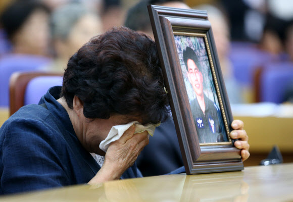 군 의문사 희생자의 한 유족이 24일 오전 국회 의원회관에서 열린 ‘군 의문사 유족이 외치는 대 국회, 국민 호소 대회’에서 아들의 영정사진을 붙잡고 눈물을 흘리고 있다.