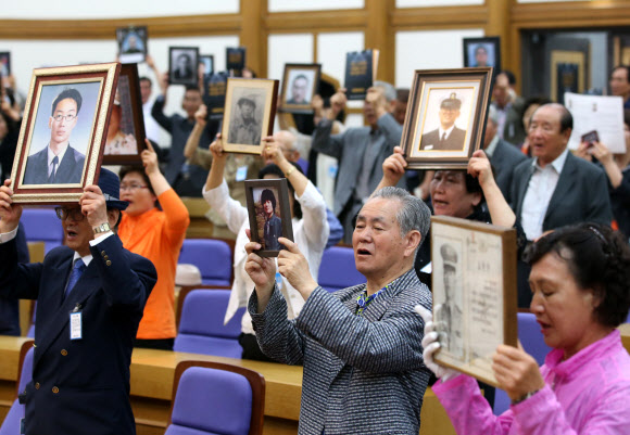 군 의문사 희생자의 유족들이 24일 오전 국회 의원회관에서 열린 ‘군 의문사 유족이 외치는 대 국회, 국민 호소 대회’에서 아들의 영정을 들고 진상규명과 명예회복을 촉구하고 있다.