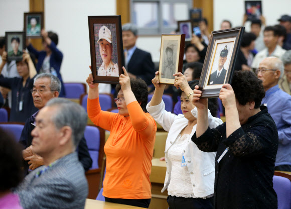 군 의문사 희생자의 유족들이 24일 오전 국회 의원회관에서 열린 ‘군 의문사 유족이 외치는 대 국회, 국민 호소 대회’에서 아들의 영정을 들고 진상규명과 명예회복을 촉구하고 있다.