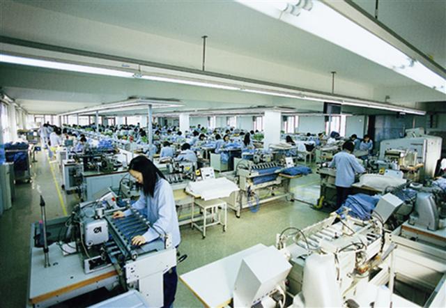 한 근로자가 해운대구 반여동 공장에서 신사복 바지를 검수하는 모습.<br>파크랜드 제공