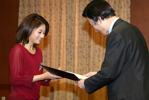 윤병세 외교부장관이 27일 외교부청사에서 열린 아프리카 정책자문 등을 위해 구성된 ‘아프리카의 친구들’ 위촉식에서 김윤지 KBS 아나운서에게 위촉장을 수여하고 있다. 연합뉴스