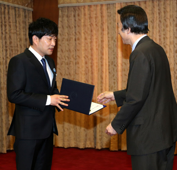 윤병세 외교부장관이 27일 외교부청사에서 열린 아프리카 정책자문 등을 위해 구성된 ‘아프리카의 친구들’ 위촉식에서 탤런트 손현주씨에게 위촉장을 수여하고 있다. 연합뉴스