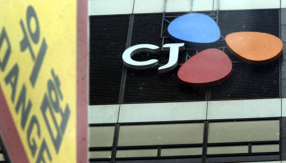 27일 서울 중구 CJ그룹 본사 사옥 앞의 간판이 위험을 알리는 도로표지판과 겹쳐 보이고 있다.  해외 비자금 조성 의혹 등에 대한 검찰 수사와 시세조종, 미공개정보 이용 등의 불공정거래 혐의에 대한 금융감독원의 조사 등으로  CJ그룹 소속 상장사 시가총액 1조1천억원이 증발했다.  연합뉴스