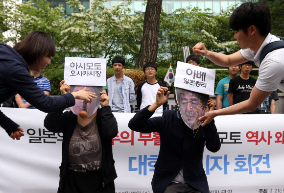 29일 오전 서울 종로구 중학동 주한일본대사관 앞에서 열린 일본 하시모토 유신회 대표 위안부 왜곡 망언 규탄 대학생 기자회견에서 21세기한국대학생연합 회원들이 하시모토 대표와 아베 총리에게 계란을 던지는 퍼포먼스를 하고 있다. 연합뉴스
