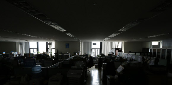 냉방 수요 증가와 원자력 발전소의 가동 중단으로 올여름 심각한 전력난이 예상되는 가운데 29일 점심시간에 안전행정부 사무실에 불을 꺼놔 어두컴컴하다. 점심을 일찍 먹고 사무실에 들어온 직원들은 창문으로 들어오는 빛으로 업무를 보고 있다. 연합뉴스
