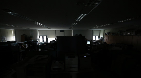 냉방 수요 증가와 원자력 발전소의 가동 중단으로 올여름 심각한 전력난이 예상되는 가운데 29일 점심시간에 안전행정부 사무실에 불을 꺼놔 어두컴컴하다. 점심을 일찍 먹고 사무실에 들어온 직원들은 창문으로 들어오는 빛으로 업무를 보고 있다. 연합뉴스