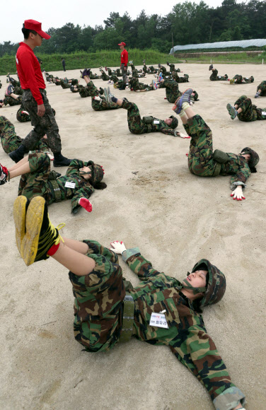 원광정보예술고교 학생들이 29일 전북 익산시 육군부사관학교에서 열린 ‘여학생 나라사랑 캠프’에서 유격체조 8번 ‘온몸 비틀기’를 하면서 고통스러운 표정을 짓고 있다. 연합뉴스