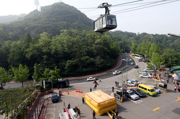 30일 오전 서울 중구 회현동1가 남산케이블카 하부 승강장에서 열린 남산 케이블카 비상상황 대비 시민 긴급구조훈련에서 소방대원들이 훈련에 임하고 있다. 연합뉴스