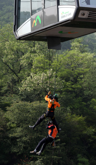 30일 오전 서울 중구 회현동1가 남산케이블카 하부 승강장에서 열린 남산 케이블카 비상상황 대비 시민 긴급구조훈련에서 소방대원들이 훈련에 임하고 있다. 연합뉴스