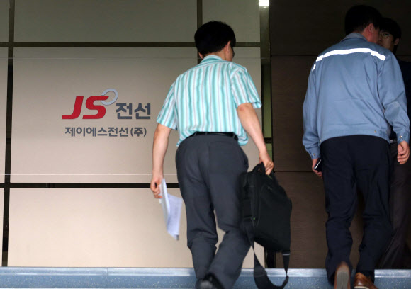 검찰 관계자들이 30일 원전 가동 중단사태의 원인이 된 불량부품을 납품한 충남 천안시 JS전선을 압수수색하기 위해 사무실에 들어가고 있다. 연합뉴스