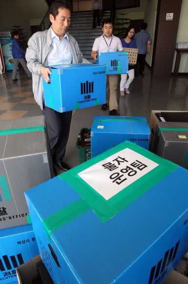 검찰 관계자들이 30일 원전 가동 중단사태의 원인이 된 불량부품을 납품한 충남 천안시 JS전선 사무실을 압수수색, 관련 자료를 압수해 나오고 있다.  연합뉴스