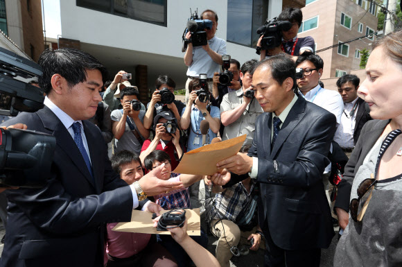 북한인권시민연합 회원들이 31일 오전 주한 라오스 대사관 앞에서 탈북 난민의 북한 송환에 반대하는 기자회견을 마친 뒤 항의 서한을 주한 라오스 대사관 관계자에게 전달하고 있다.  연합뉴스