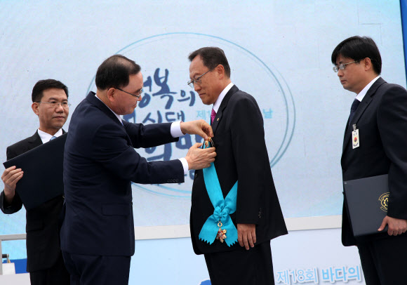 정홍원 국무총리가 31일 바다의 날을 맞아 충남 태안군 만리포해수욕장에서 열린 기념식에서 유공자들을 표창하고 있다.  연합뉴스