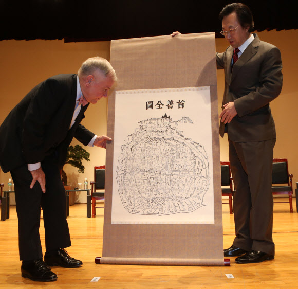 세계적인 투자전문가 짐 로저스(왼쪽)가 31일 오후 서울 안암동 고려대학교에서 열린 특별강연에 참석해 이두희 경영대학장으로부터 기념품으로 받은 ‘수선전도’를 살펴보고 있다.  연합뉴스