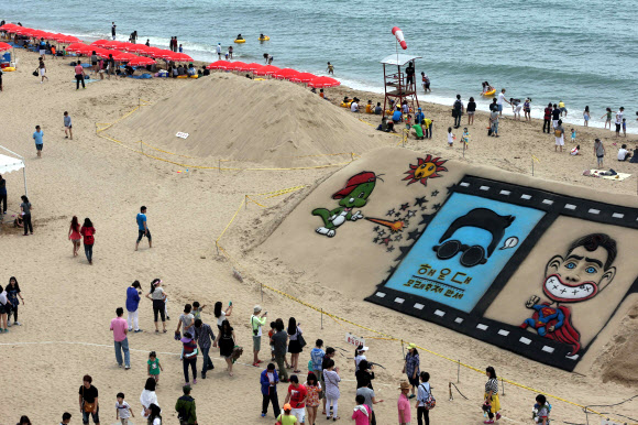 2일 부산 해운대해수욕장 백사장에서 나들이객들이 싸이의 젠틀맨을 비롯한 다양한 모래조각을 살펴보고 있다. 영화를 주제로 한 ‘해운대 모래축제’는 오는 7일부터 10일까지 열린다. 연합뉴스