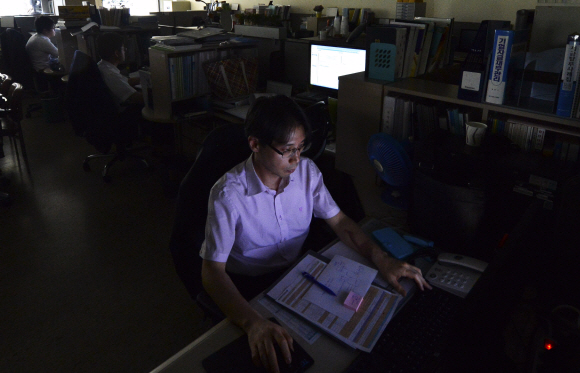 전력수급경보 준비 단계가 발령된 3일 오후 서울 삼성동 한국전력거래소의 한 사무실에 불이 꺼진 채 직원들이 업무를 보고 있다. 손형준 boltagoo@seoul.co.kr