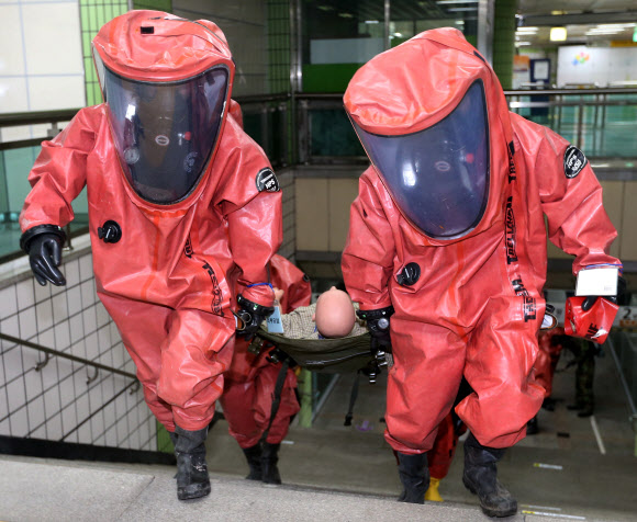 4일 오후 서울 중랑구 봉화산역에서 한국원자력의학원 주관으로 열린 ‘2013 방사능테러대응 민관군 합동훈련’에서 중앙119구조단 대원들이 방사능에 피폭된 환자를 옮기고 있다. 연합뉴스
