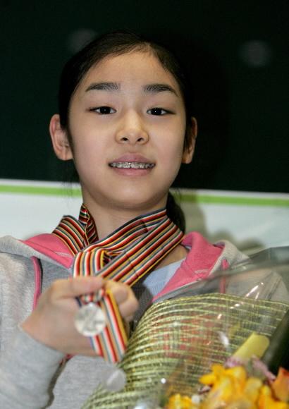 김연아 귀국 8일 인천국제공항을 통해 한국 빙상 역사를 새롭게 쓴 ‘무서운 10대 소녀’ 김연아가 귀국해 획득한 메달을 들어보이고 있다. 김연아는 올해 세계주니어피겨선수권에서 은메달을 획득했다. 연합뉴스