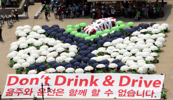 페르노리카 코리아가 5일 서울 필동 남산골 한옥마을에서 글로벌 70여 개국 1만8800명 전 직원이 동참하는 ‘책임음주의 날’ 캠페인을 통해 “음주와 운전은 함께 할 수 없습니다(Don’t Drink & Drive)”는 메시지를 전하는 대규모 플래시몹을 펼치고있다. 음주운전예방재단, 도로교통공단, 시민단체 등 500여 명과 함께 우산을 활용하여 붕대에 감긴 실제 자동차가 술잔에 빠지는 상황을 연출하고있다.  도준석 pado@seoul.co.kr