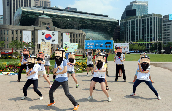 4382번째 단군왕검 탄신일을 하루 앞둔 9일 서울 시청광장에서 세계국학원청년단과 서울국학원 관계자들이 단군왕검 탈을 쓰고 ‘젠틀맨’ 댄스 플래시몹을 펼치고 있다.  연합뉴스