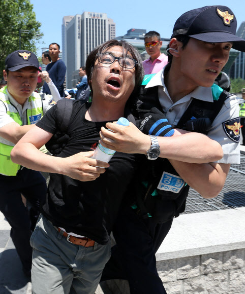 대한문 앞 임시 분향소 철거… 연행되는 쌍용차 관계자     10일 오후 서울 중구 정동 덕수궁 대한문 앞에서 쌍용차 노동조합 관계자가 기자회견을 열기 위해 화단 앞으로 들어서다 경찰에 연행되고 있다. 경찰은 기자회견이 불법 폭력집회로 번질 우려가 있다며 이를 허가하지 않았다. 서울 중구청은 이날 오전 9시20분께 대한문 앞에 설치된 쌍용자동차 범국민대책위원회 임시 분향소를 철거했다. 연합뉴스