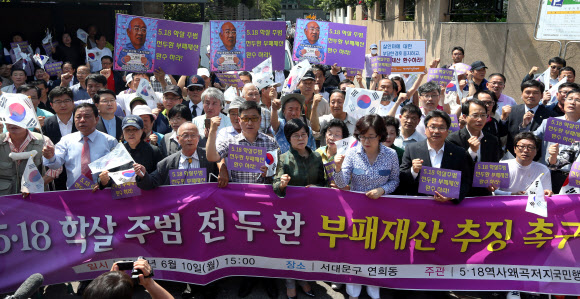 북새통 이룬 전두환 전 대통령 사저 인근 5·18 역사왜곡저지대책위 회원들이 10일 오후 서울 서대문구 연희동 전두환 전 대통령 사저 인근에서 전 전 대통령의 추징금 미납 규탄 기자회견을 하고 있다.  연합뉴스