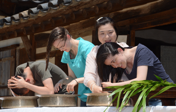 여름의 길목 단오를 앞두고 10일 오전 국립민속박물관에서 글로벌빌리지센터 외국인들이 창포물에 머리감기 체험을 하고 있다.  도준석 pado@seoul.co.kr
