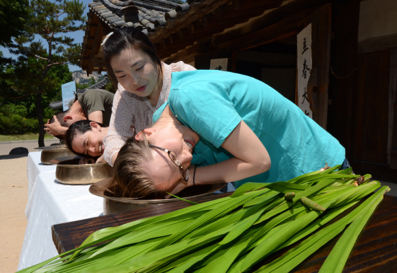 여름의 길목 단오를 앞두고 10일 오전 국립민속박물관에서 글로벌빌리지센터 외국인들이 창포물에 머리감기 체험을 하고 있다.  도준석 pado@seoul.co.kr